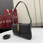 Black Gucci shoulder bag with top handle and flap front, gold clasp detail