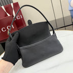 Black Gucci shoulder bag with top handle and flap front, includes black wrist strap