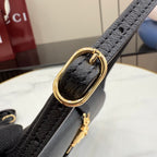 Black Gucci shoulder bag strap with gold ring hardware, close-up