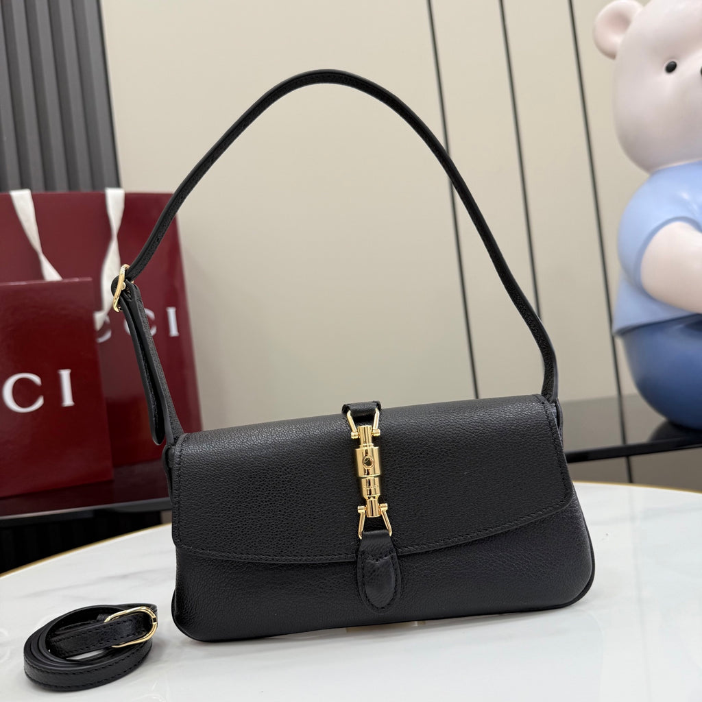Black Gucci shoulder bag with top handle, flap front, and gold clasp hardware