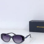 Bvlgari dark sunglasses with purple-tinted lenses and thick black frames