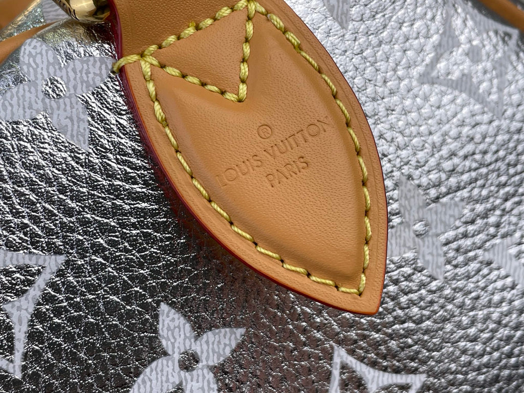 Tan leather tab with Louis Vuitton Paris imprint and yellow edge stitching