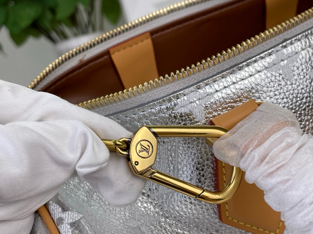 Monogram canvas bag with tan leather handle pull and gold clasp hardware