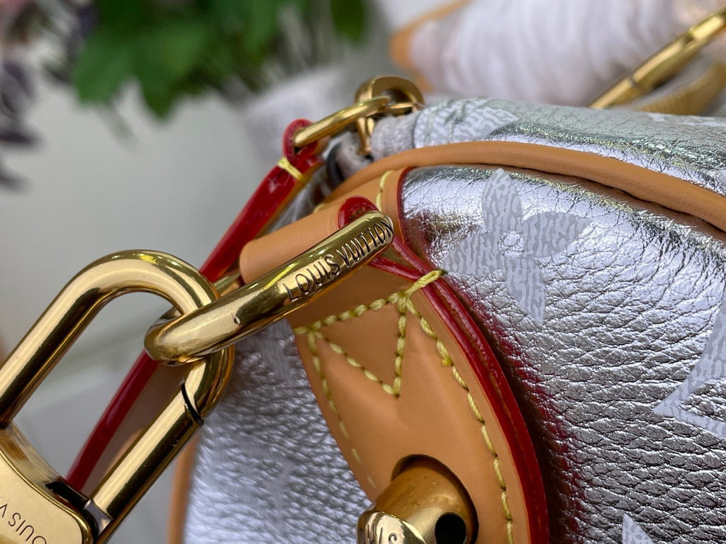Monogram canvas bag with tan leather trim, red lining panel, and gold hardware