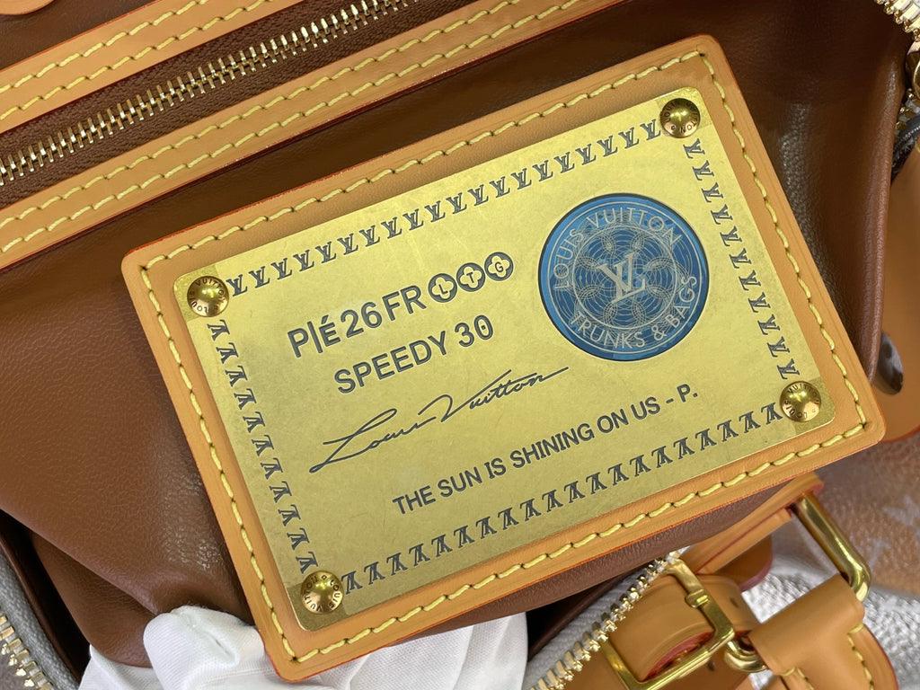 Tan leather wallet-style patch with printed label and gold stud corners on bag