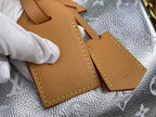 Tan leather luggage tag with Louis Vuitton logo on textured silver canvas