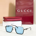 Square sunglasses with light blue lenses, dark frame, and gold metal accents