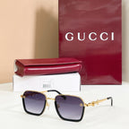 Square sunglasses with dark purple lenses, black frame, and gold metal accents