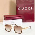 Square sunglasses with brown gradient lenses, gold frame, and gold metal accents