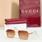 Square sunglasses with amber lenses, gold frame, and gold metal decorative links