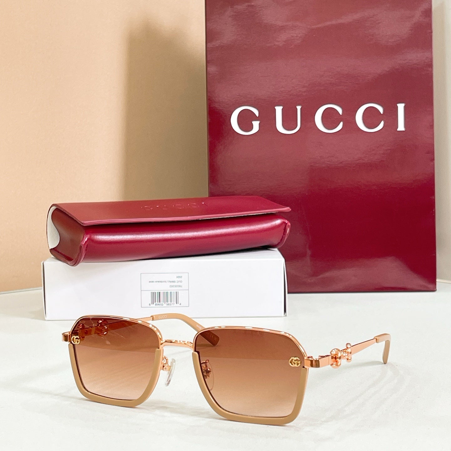 Square sunglasses with amber lenses, gold frame, and gold metal decorative links