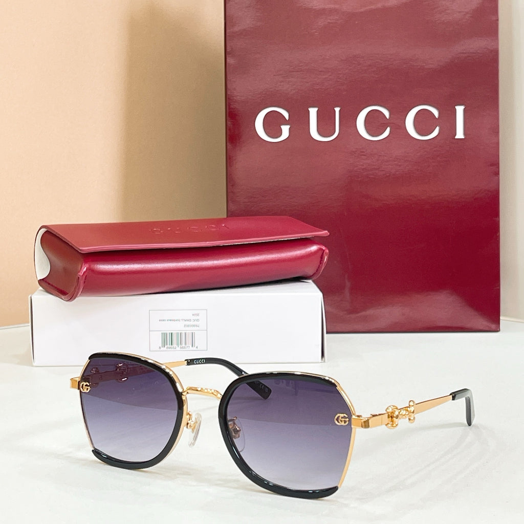 Black round sunglasses with dark purple gradient lenses and gold logo hinges.