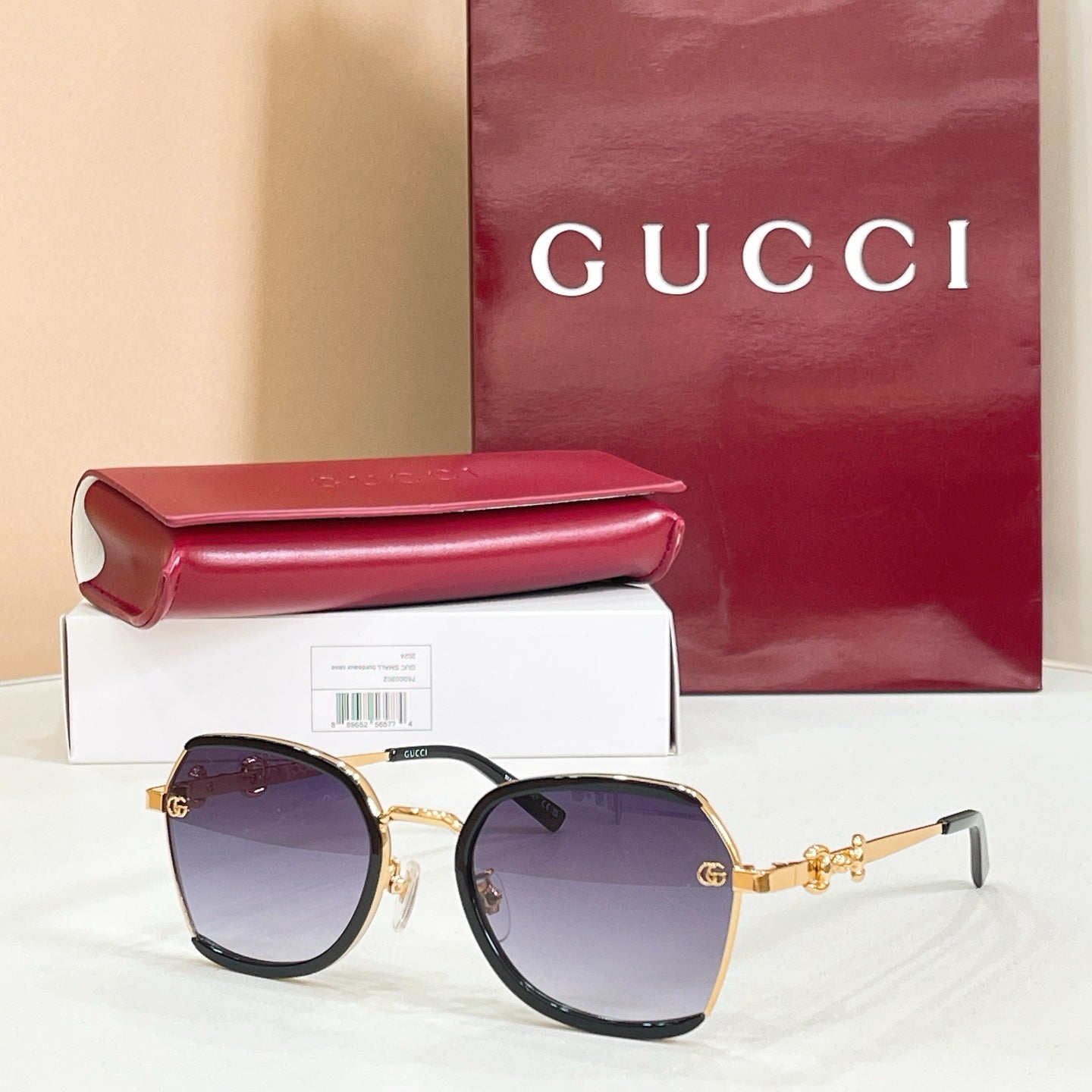 Black round sunglasses with dark purple gradient lenses and gold logo hinges.