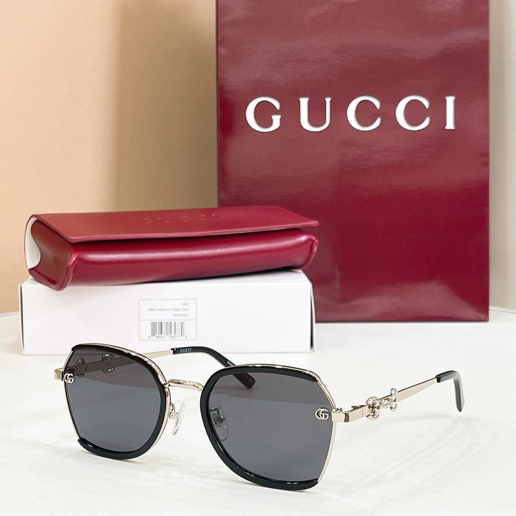 Black round sunglasses with dark gray lenses and gold logo hinges.