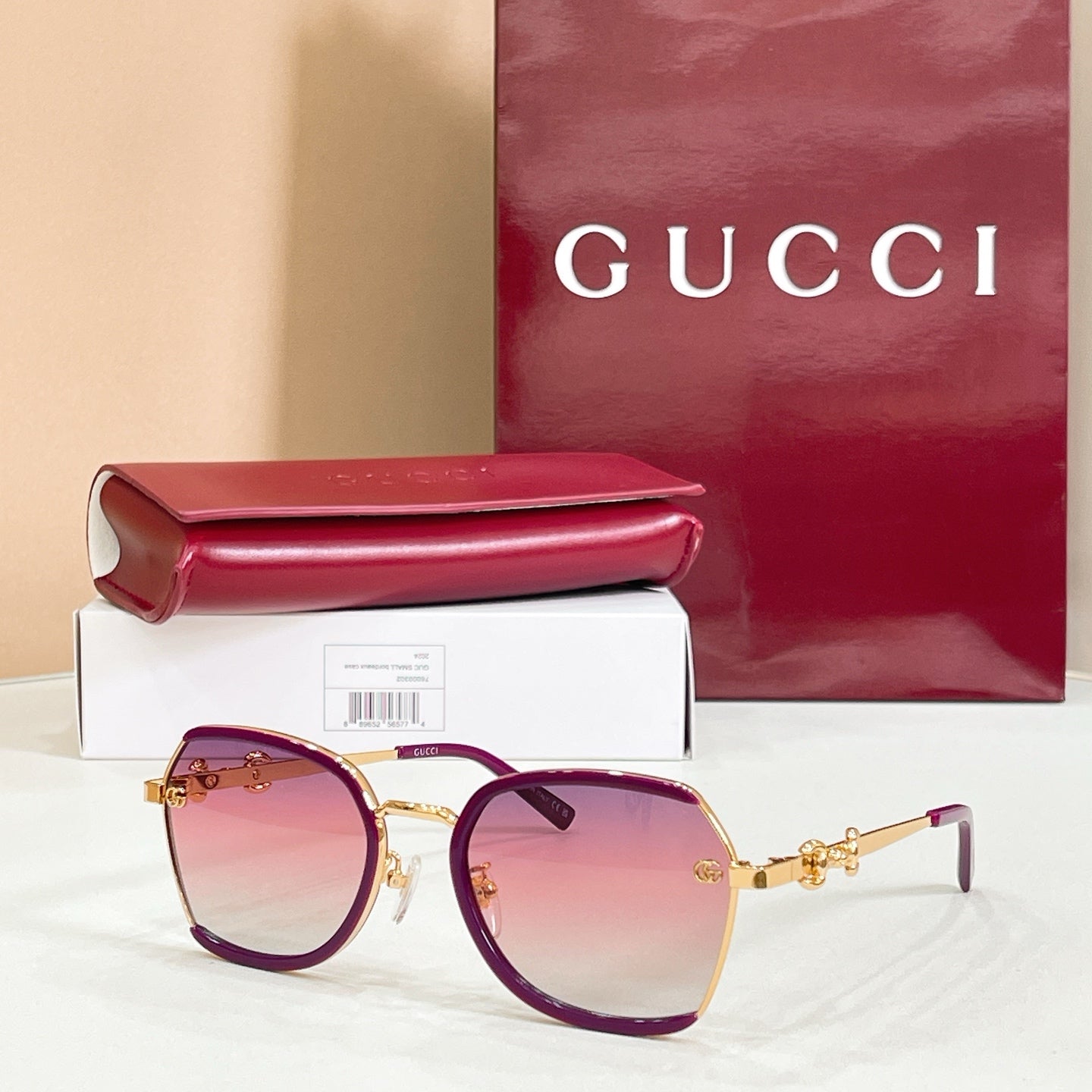 Purple round sunglasses with pink gradient lenses and gold logo hinges.