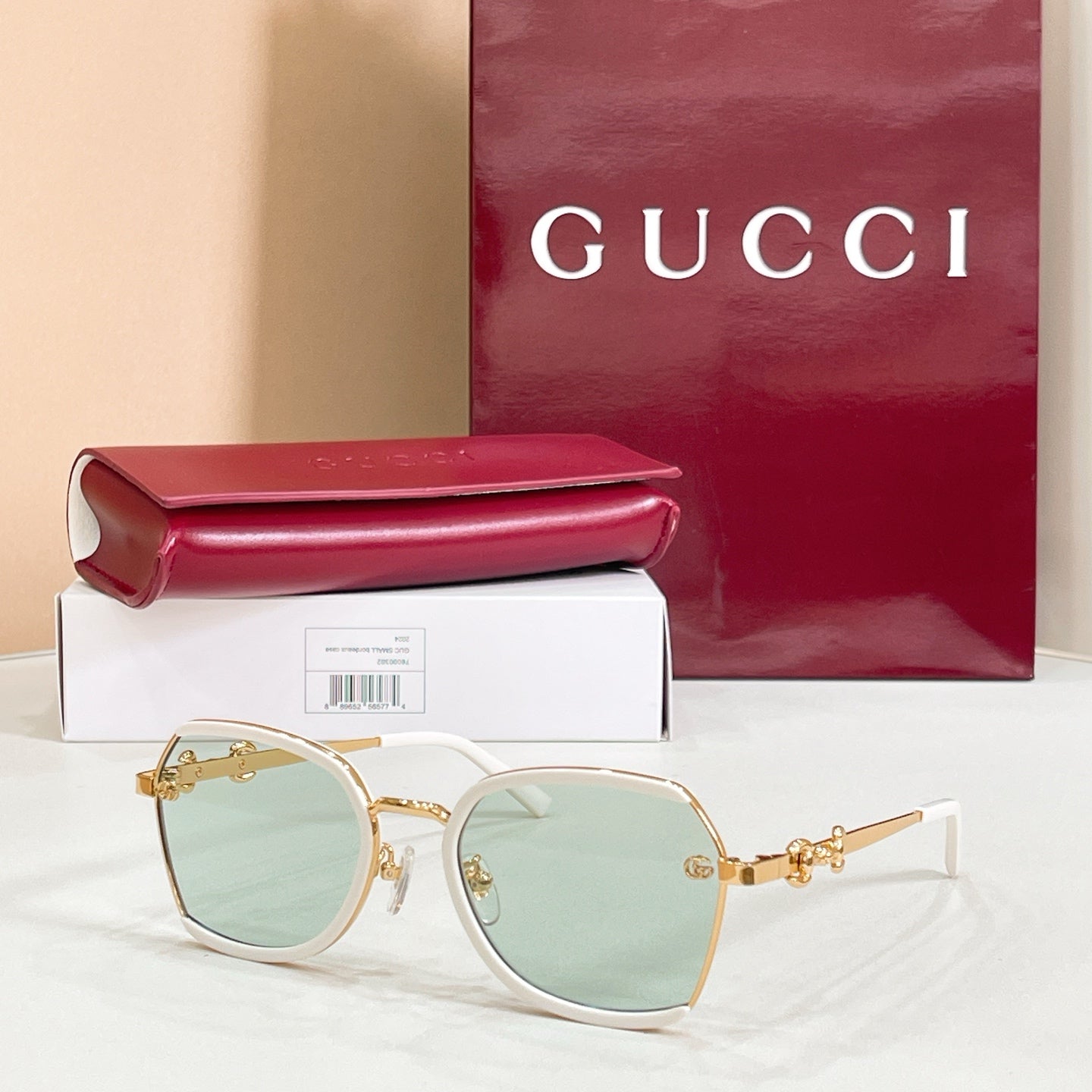Light frame round sunglasses with mint-green lenses and gold logo hinges.