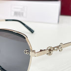 Gold logo temple and hinge on black round sunglasses.