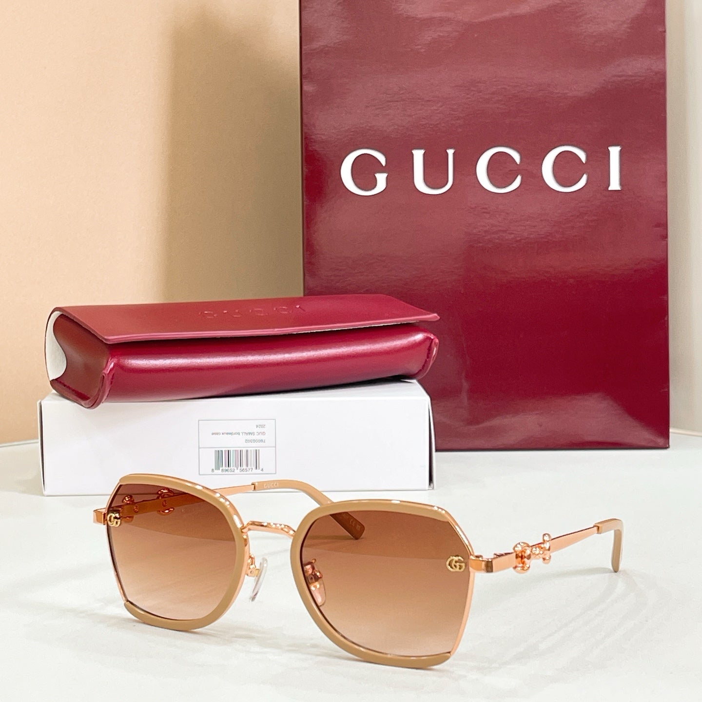 Gold-and-white round sunglasses with tan gradient lenses and logo hinges.