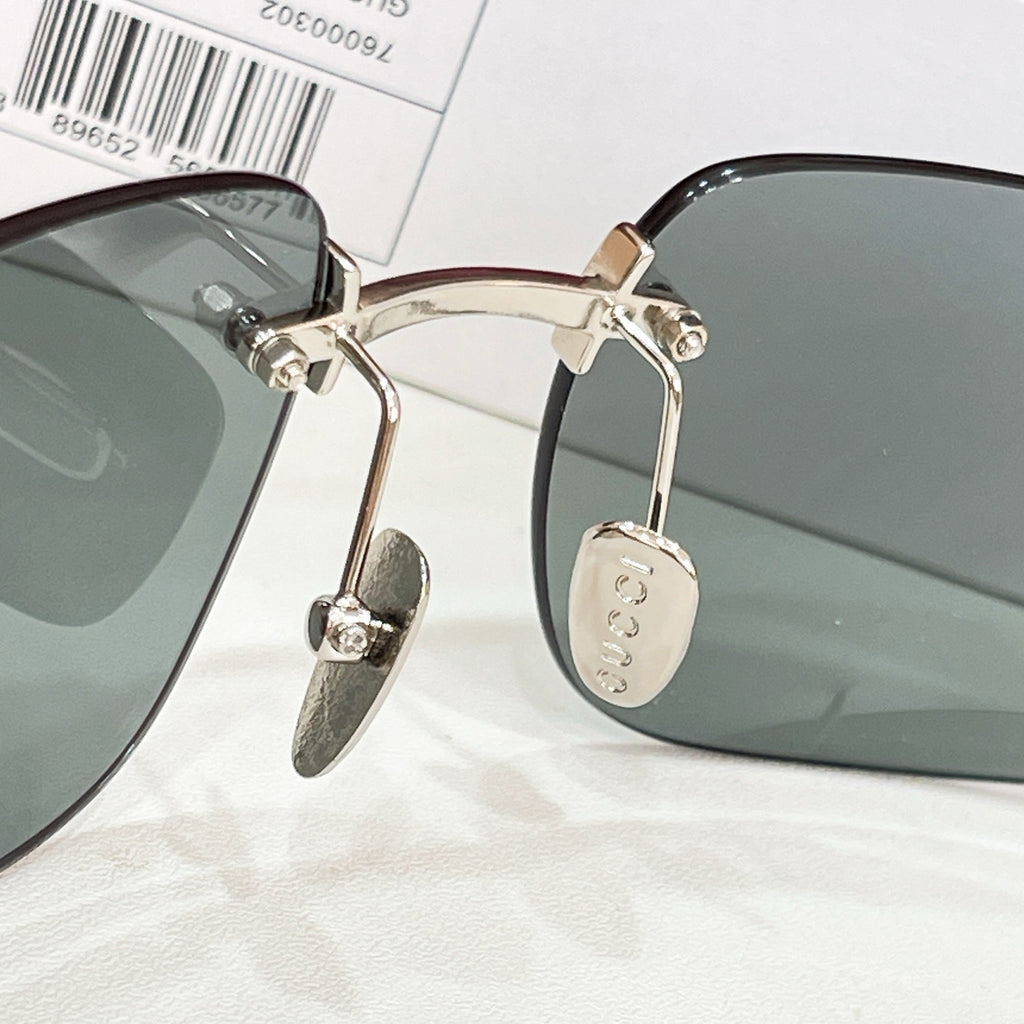 Sunglasses close-up with gold metal temples and gray-green lenses