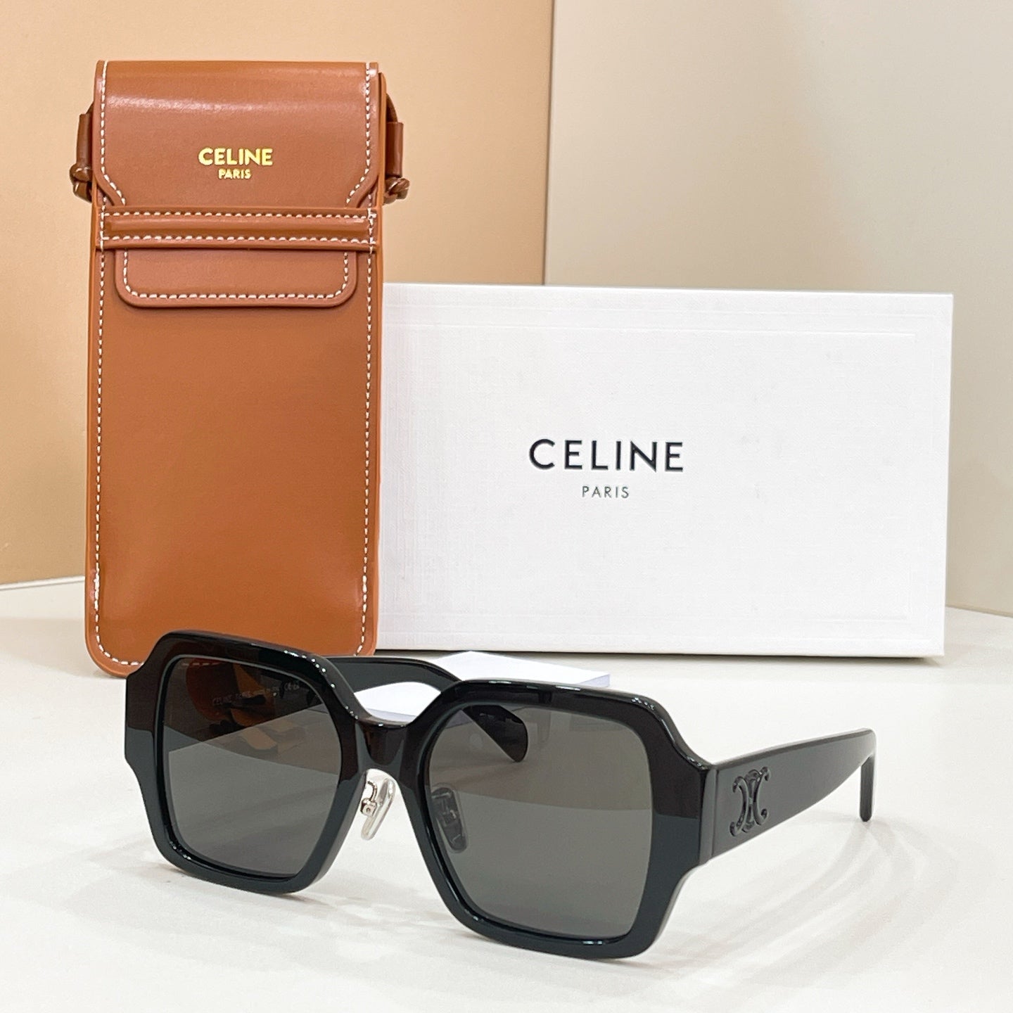 Celine glasses with square black frames and dark tinted lenses, gold logo detail