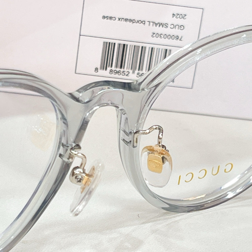 Gucci eyeglasses close-up of clear frame bridge and gold logo detail