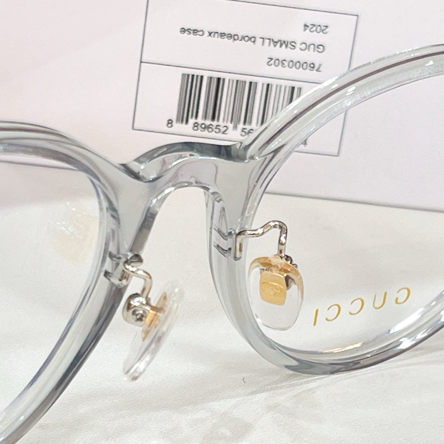 Gucci eyeglasses close-up of clear frame bridge and gold logo detail