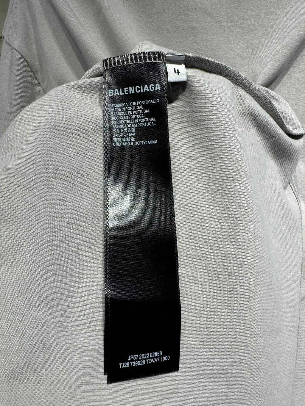 Light gray T-shirt with black size and care tag under the collar seam