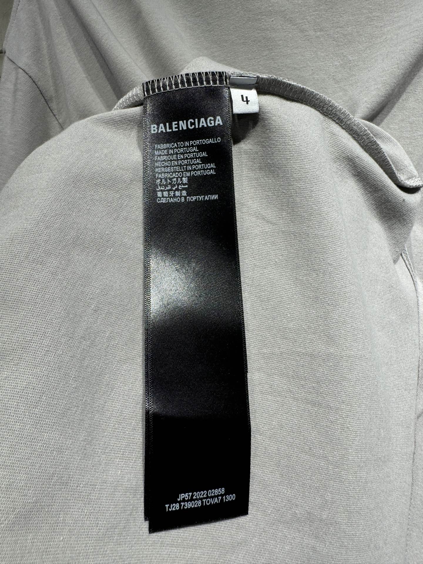 Light gray T-shirt with black size and care tag under the collar seam