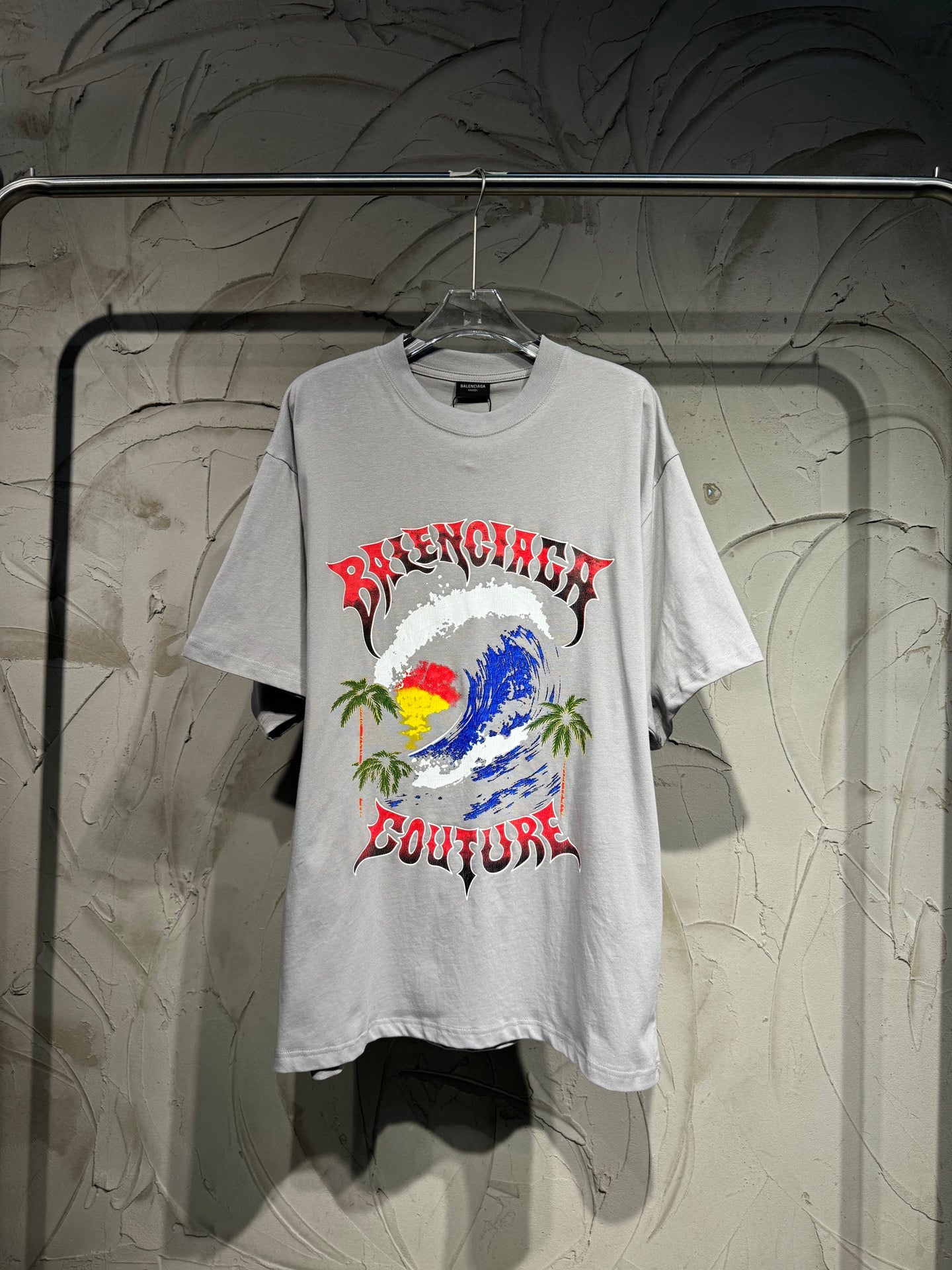 Light gray short-sleeve T-shirt with colorful logo graphic and palm trees