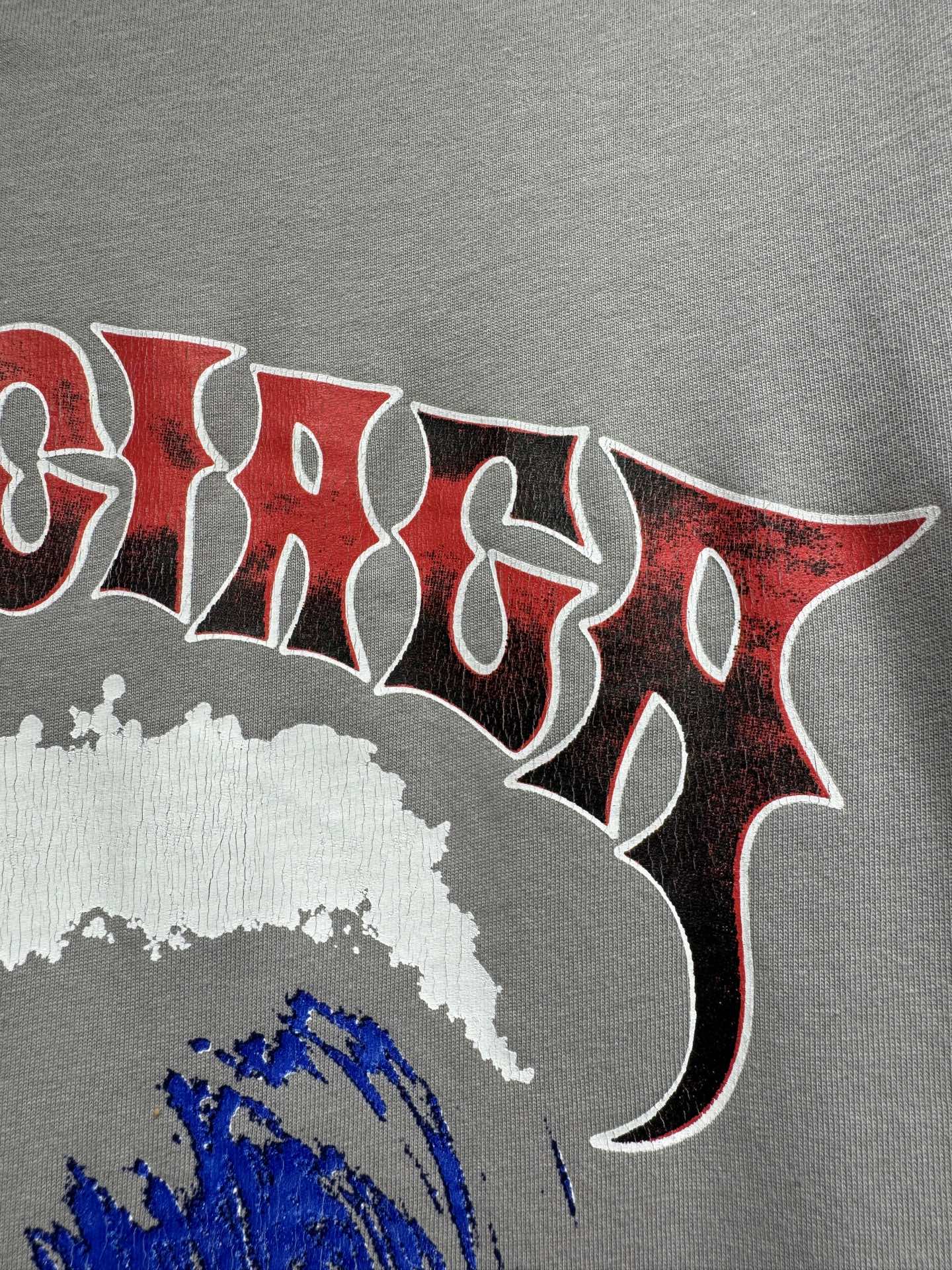 Light gray T-shirt with large red gothic-style lettering and white splatter