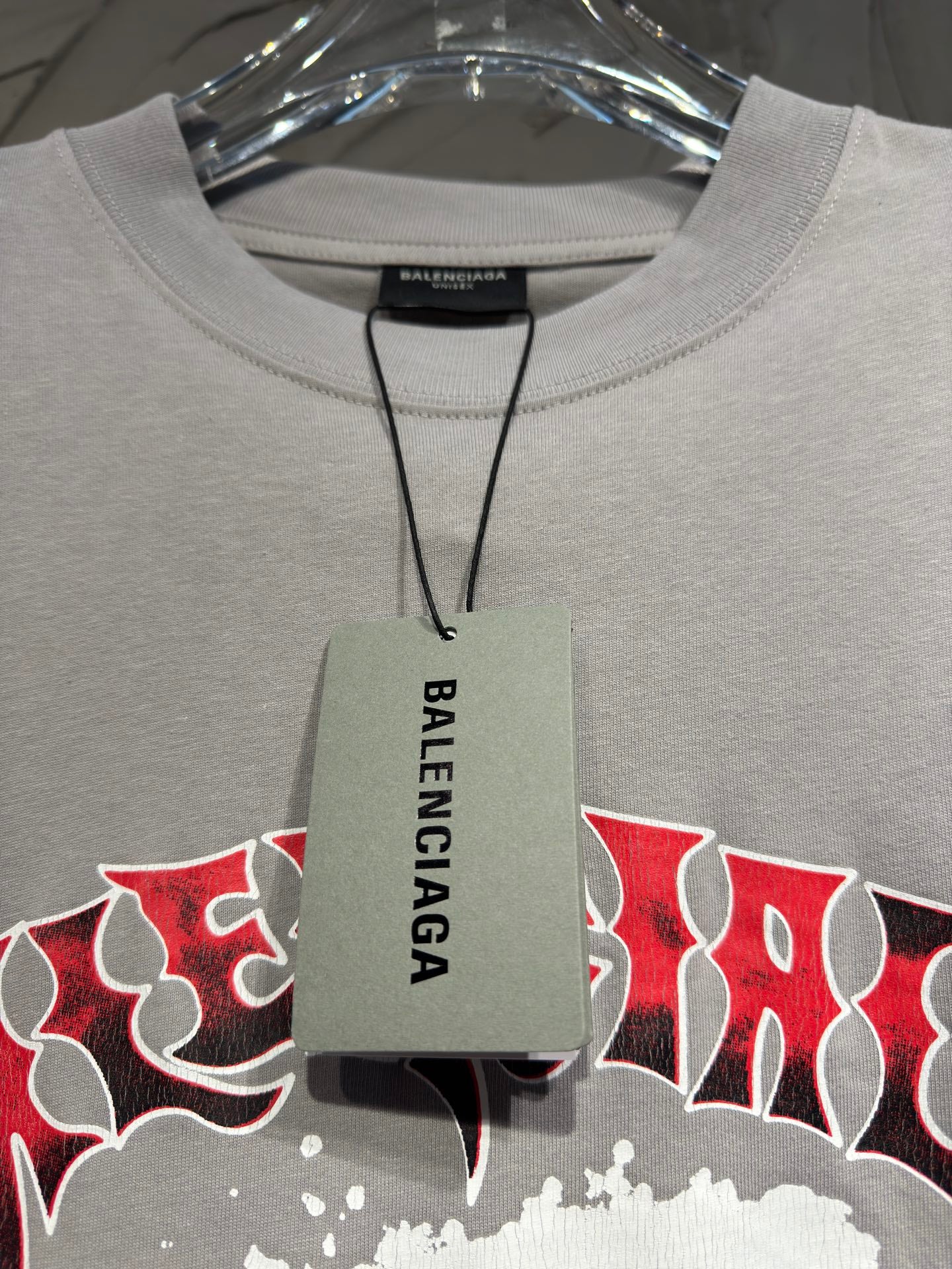 Light gray crewneck T-shirt with hanging Balenciaga tag at the neckline