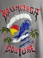 Light gray short-sleeve T-shirt with colorful face graphic, palms, and “Couture” text