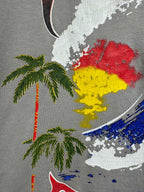 Light gray T-shirt close-up of colorful face graphic with palm tree motifs