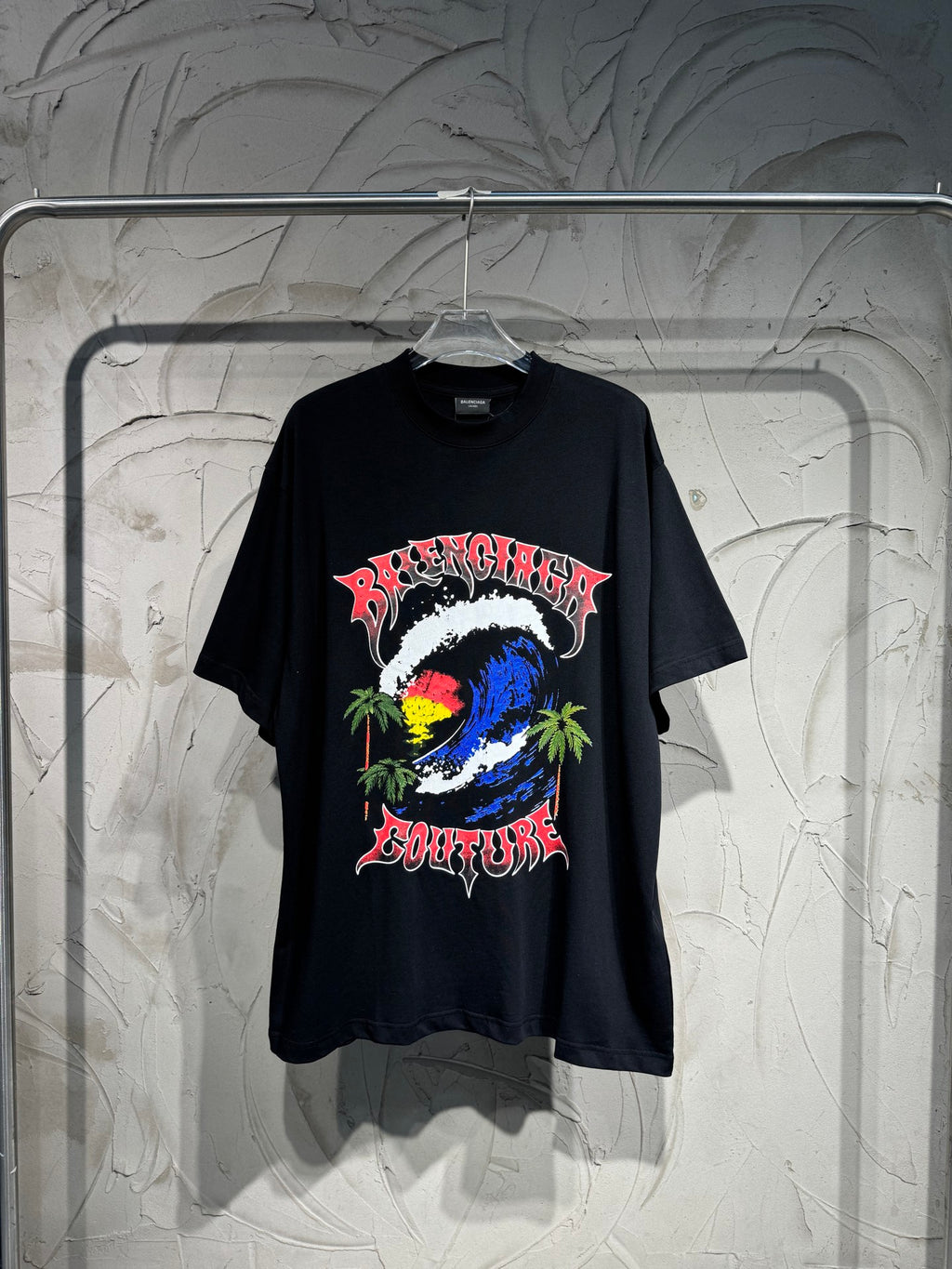 Black graphic T-shirt with colorful globe, palm trees, and stylized lettering on front