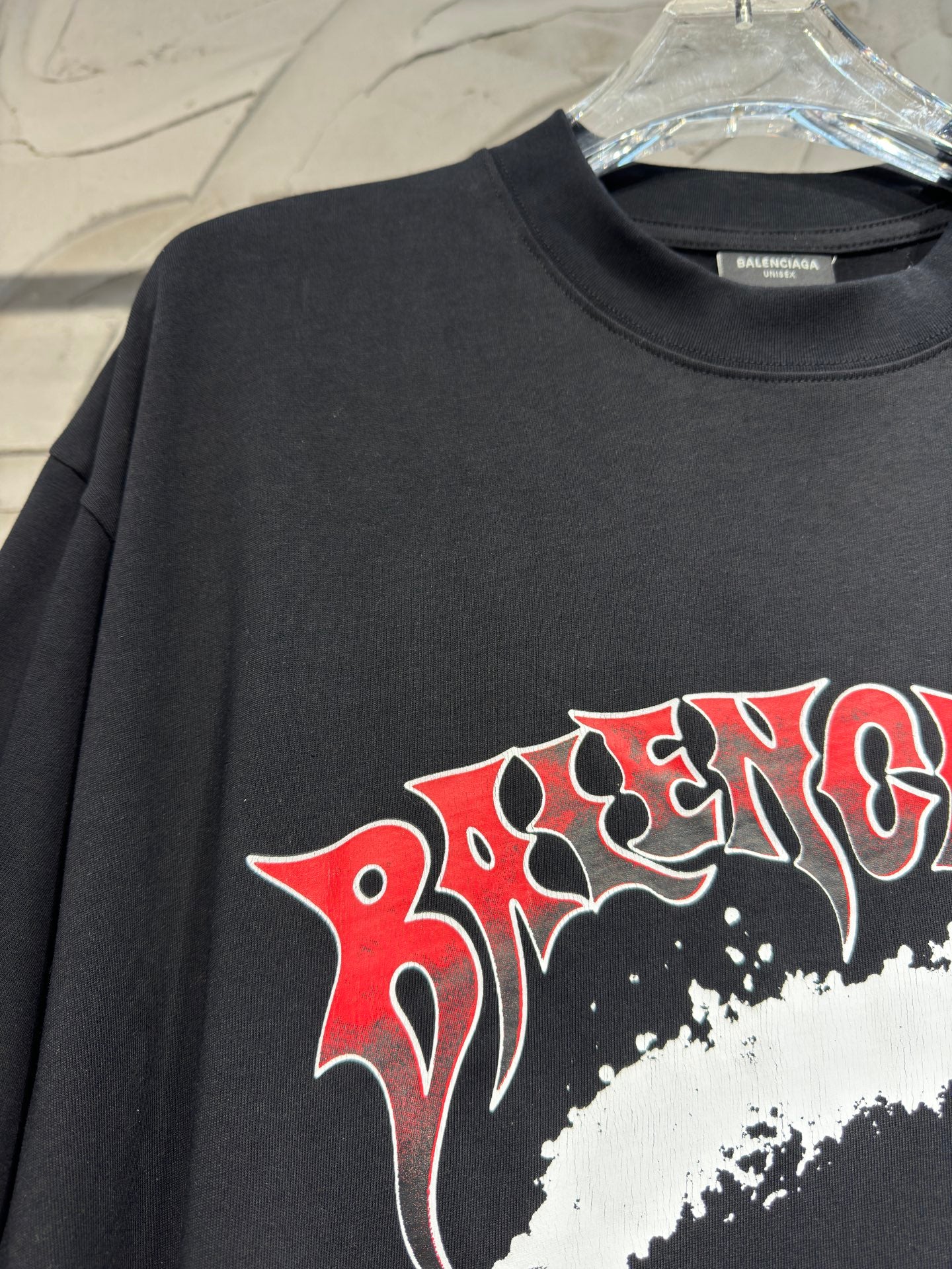 Charcoal graphic T-shirt showing red-and-white stylized lettering across chest