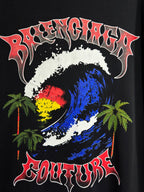 Black graphic T-shirt with colorful globe, palm trees, and bold stylized text