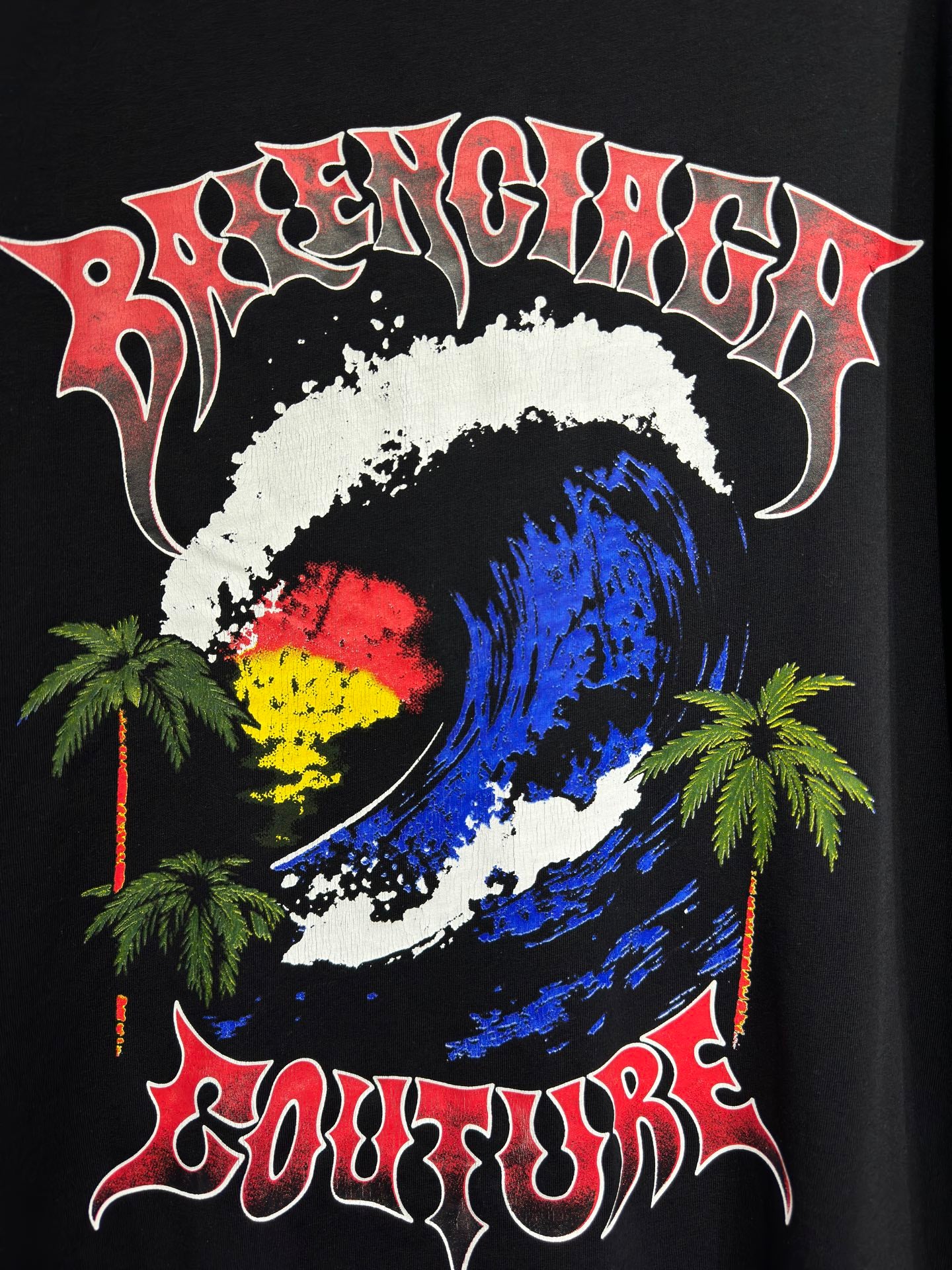Black graphic T-shirt with colorful globe, palm trees, and bold stylized text