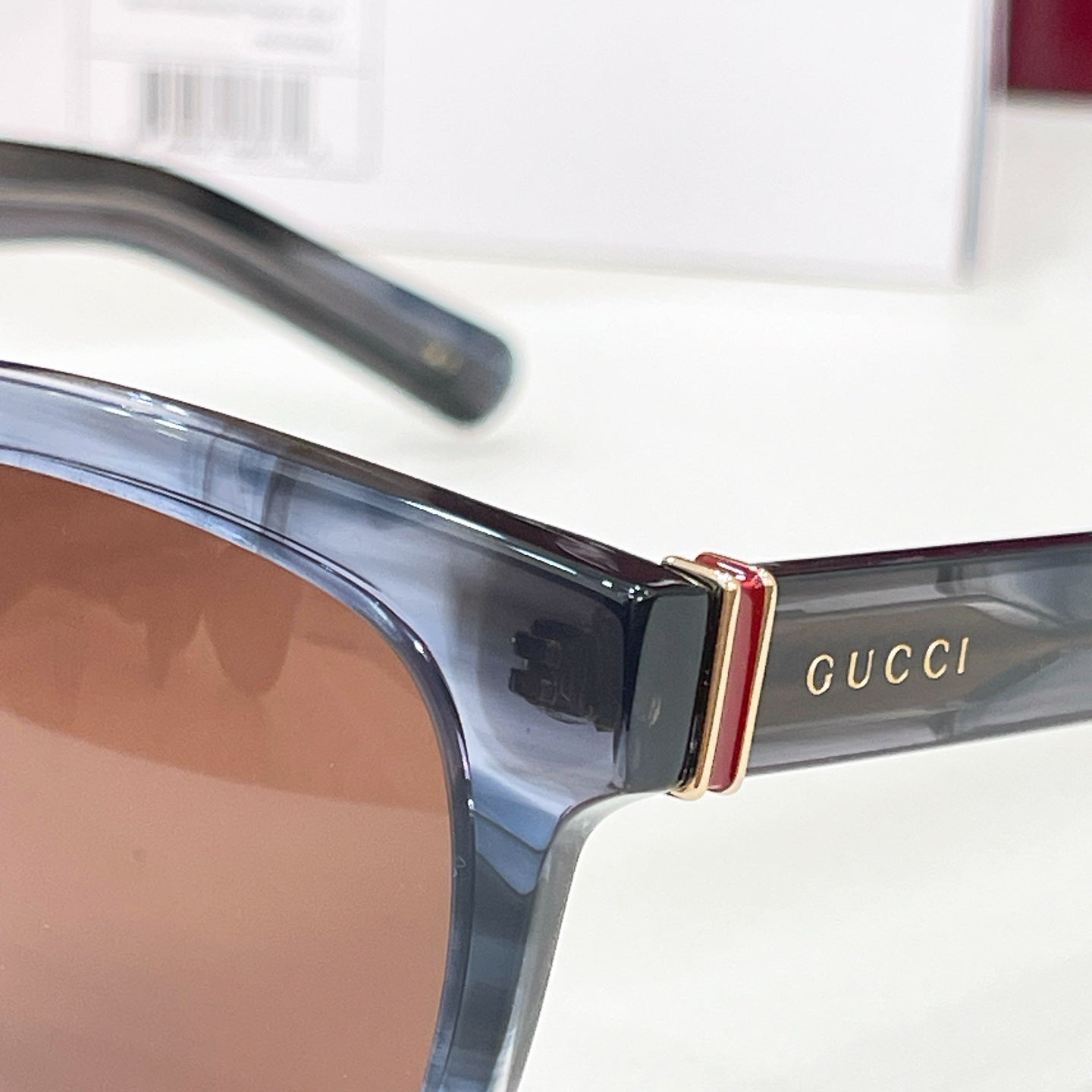 Gucci sunglasses close-up of blue frame and gold logo bar