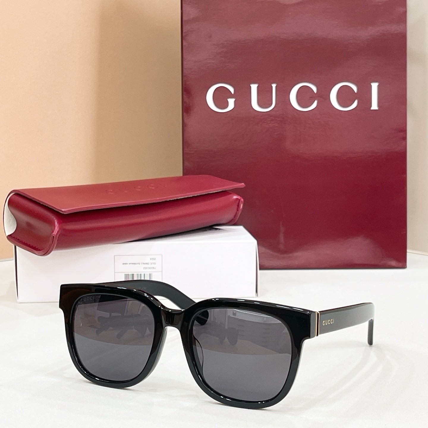 Gucci square sunglasses with black frames and dark gray lenses