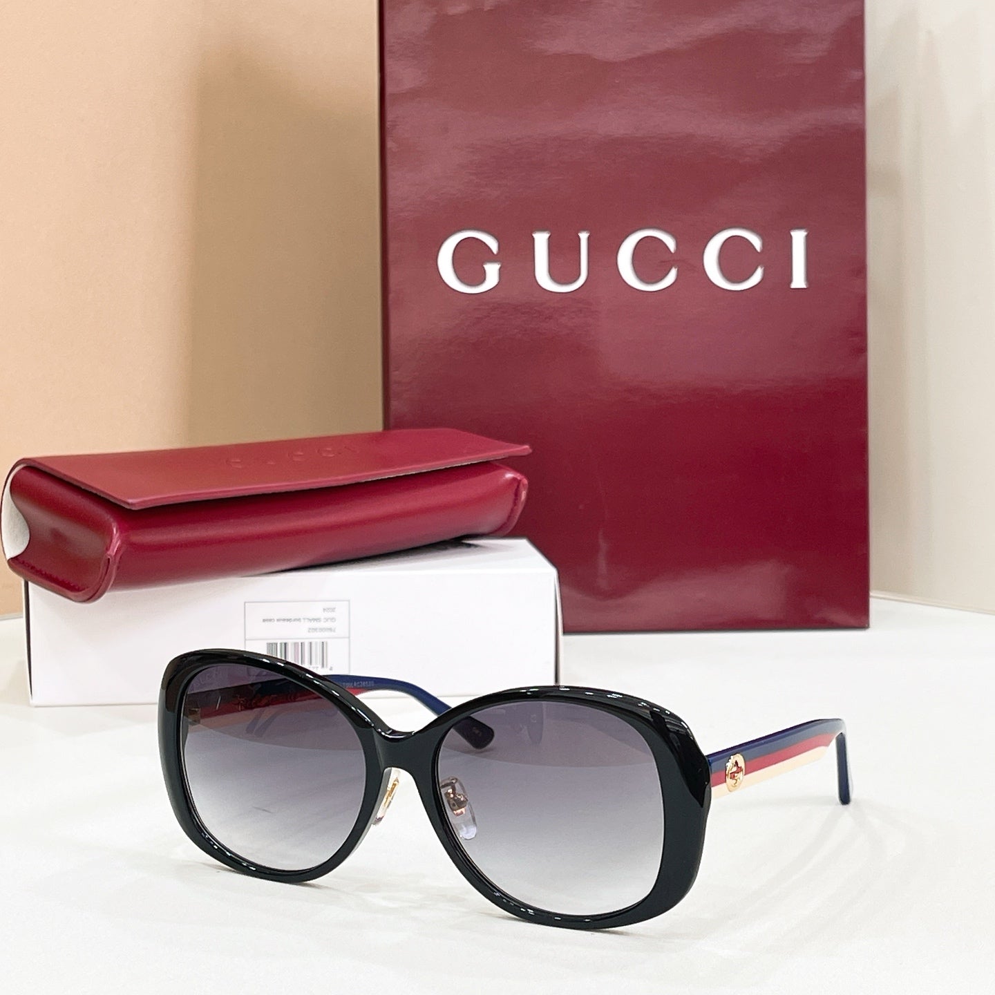 Black round sunglasses with dark lenses and striped temple detail
