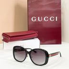 Black round sunglasses with dark lenses and gold-tone bridge detail