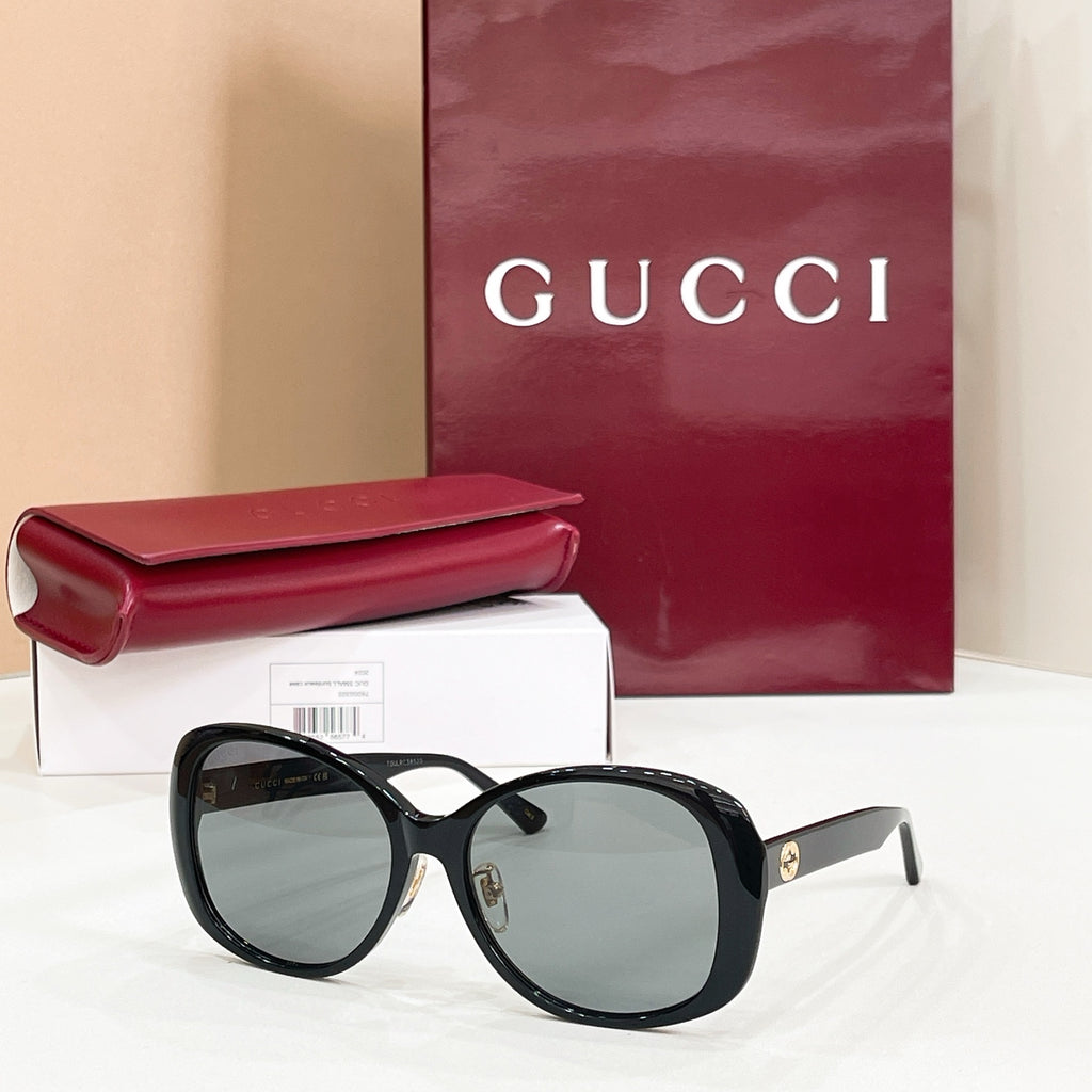 Black oversized sunglasses with dark lenses and striped temple accents