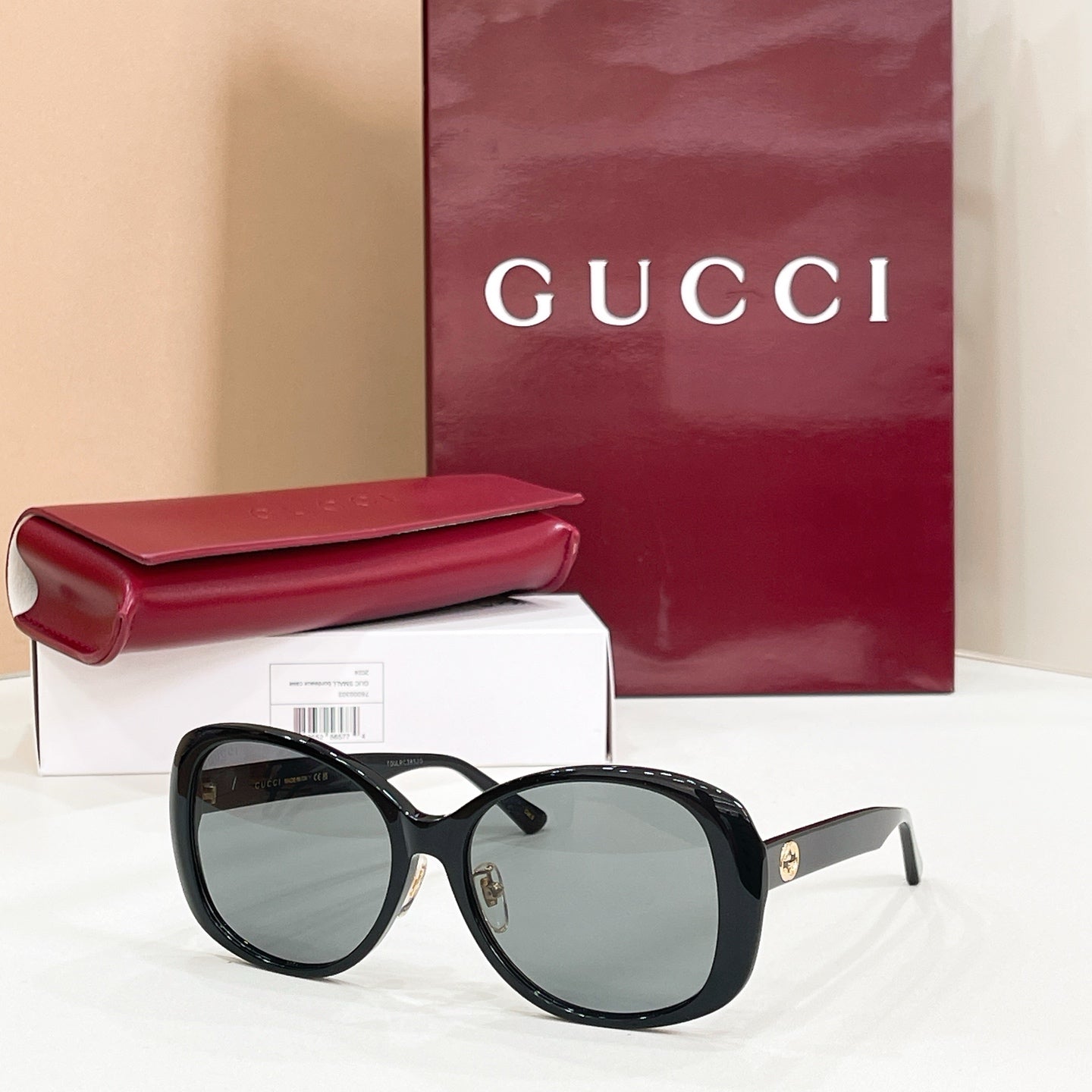 Black oversized sunglasses with dark lenses and striped temple accents