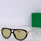 Dark sunglasses with amber-tinted lenses, gold-tone bridge detail and cat-eye shape