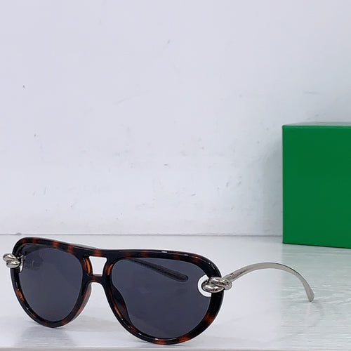 Tortoiseshell sunglasses with dark lenses and gold-tone bridge detail, round cat-eye style