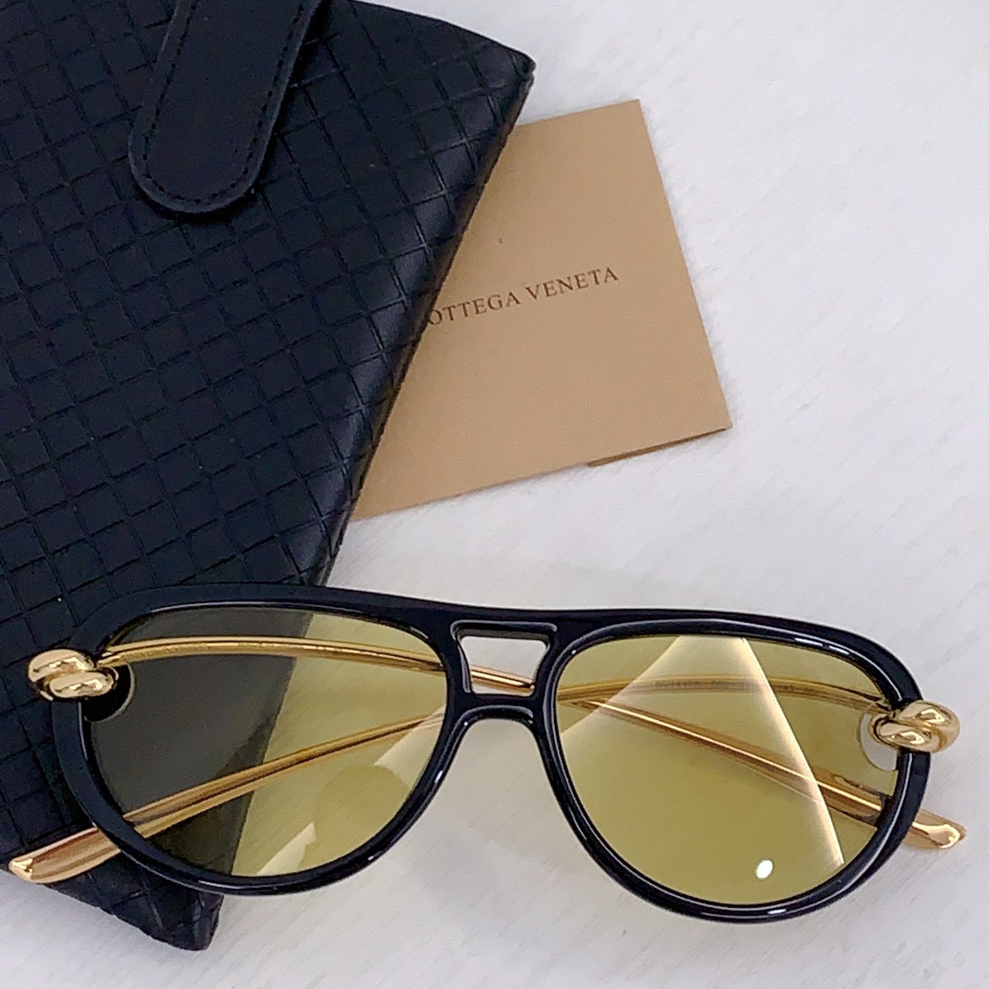 Navy sunglasses with gold-tone bridge and amber-tinted lenses, cat-eye frame
