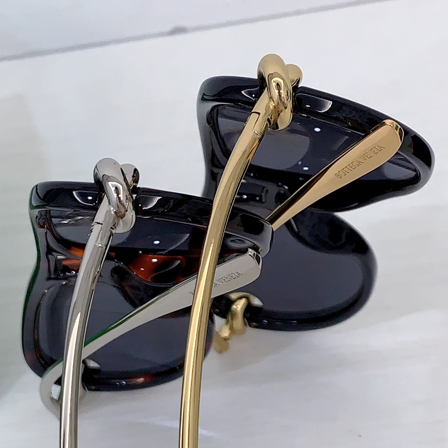 Assorted sunglasses pair with black frames, one silver-tone and one gold-tone bridge hardware