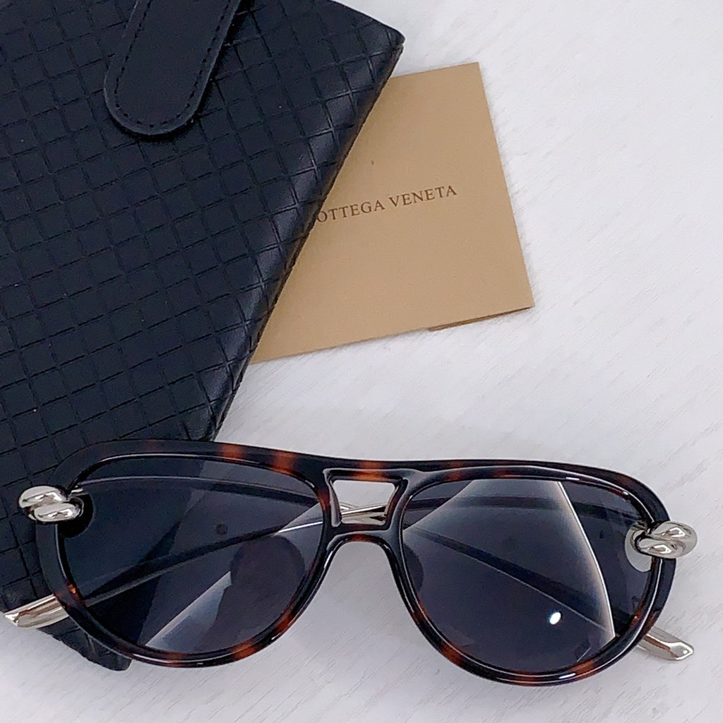 Tortoiseshell sunglasses with dark lenses and silver-tone accents, cat-eye frame