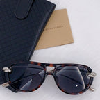 Tortoiseshell sunglasses with dark lenses and silver-tone accents, cat-eye frame