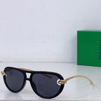 Black sunglasses with dark lenses, gold-tone bridge detail and narrow cat-eye frame